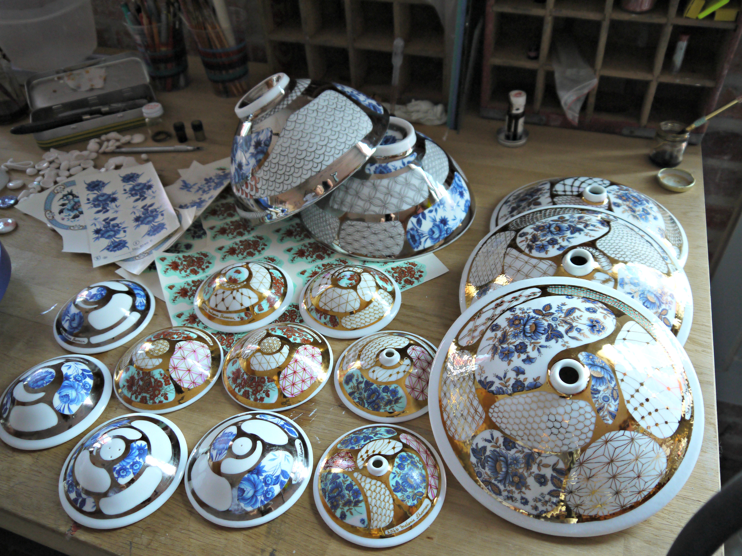 Working on some small and large budvases, salt & pepper shaker, applying decals and gold luster